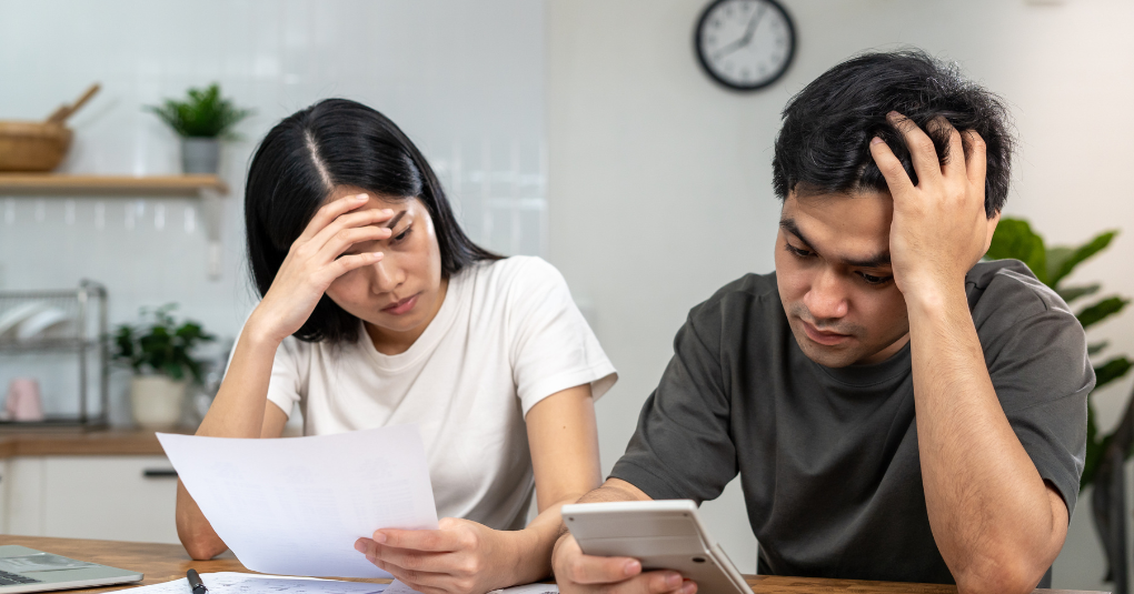 Stressed couple looking at financial records.