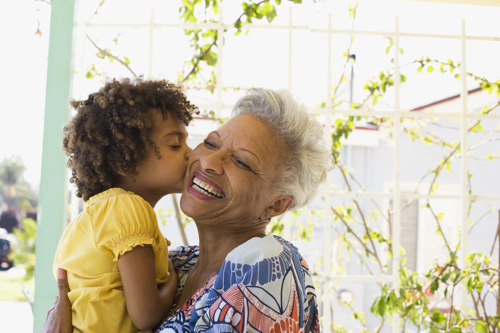 Grandmother enjoying time with her grandkids after sticking to a personal financial plan.